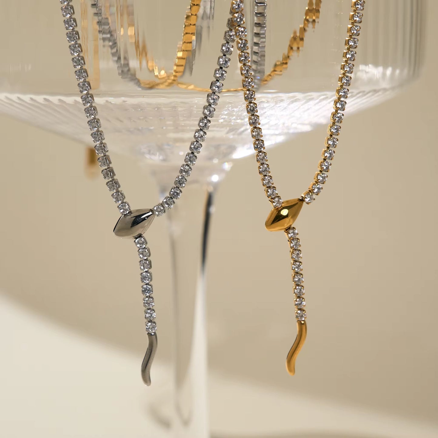 Eine Frau, die eine vergoldete Edelstahlkette mit einem Schlangenanhänger trägt, der mit Zirkoniasteinen verziert ist.