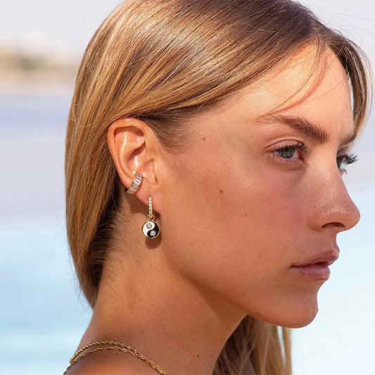 Nahaufnahme des Ohrs einer Frau, die Ohrringe trägt, mit unscharfem Hintergrund im Freien