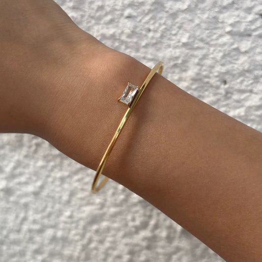 Vergoldetes Armband, das von einer Frau getragen wird.